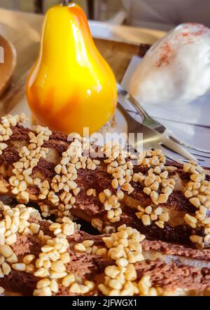 Délicieux gâteaux frais eclairs et dessert en forme de poire sur une assiette en bois avec fourchettes, confiserie. Banque D'Images