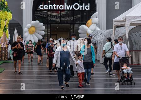 Les personnes portant des masques de visage comme mesure préventive contre la propagation de Covid-19 vu marcher en face du monde central à Bangkok, Thaïlande. Banque D'Images