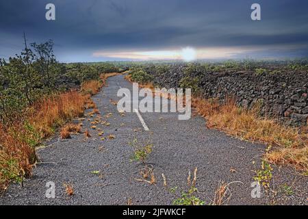 Route vide à travers un champ avec de l'herbe brûlée et ciel nuageux avec espace de copie. Une route de campagne courbée ou une route asphaltée ouverte entre les terres sèches à proximité Banque D'Images