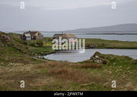 Deux vieilles maisons de chaume et maisons d'hôtes sur une crique près de Berneray Harbour, dans le détroit de Harris, Berneray Isle, Outer Hebrides, Écosse. Banque D'Images