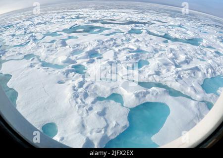 Vue œil de poisson à travers une fenêtre ronde. OCÉAN ARCTIQUE - Une banquise de plusieurs années glisse le long du côté tribord du garde-côte Healy alors que le navire se dirige vers le nord dans des glaces encore plus épaisses. « Vous pouvez dire qu'il s'agit d'une banquise de plusieurs années à côté des bassins de fonte bleu clair qui se sont formés au-dessus de la banquise », a déclaré Pablo Clemente-Col—n, scientifique en chef au U.S. National Ice Centre. Océan Arctique, août (2009) crédit : P.Kelley, USCG Banque D'Images