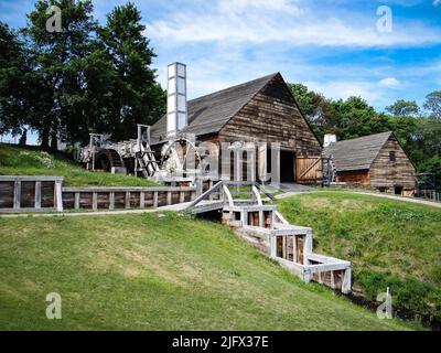 Saugus Iron Works Forge and Mill Ñ Une vue de la forge de Saugus Iron Works, dans le Massachusetts, ainsi que de l'usine de laminage et de découpe. La forge a utilisé un grand marteau pour comprimer le fer. Le forgeage a renforcé le fer, qui, en dehors du haut fourneau, était fragile. Le moulin à rouler et à coudre ferait des barres de fer qui pourraient être coupées dans des choses comme des ongles. L'eau de la rivière Saugus alimente les deux. Crédit : A.Demas/USGS. Banque D'Images