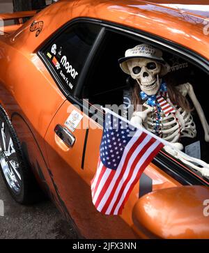 Un squelette en plastique de nouveauté porte un drapeau américain dans un Dodge Challenger 2011 exposé lors d'un salon automobile du 4 juillet à Santa Fe, Nouveau-Mexique. Banque D'Images