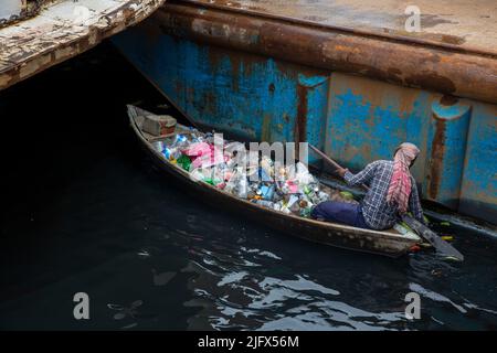 Un homme collecte les déchets plastiques du fleuve Buriganga, Dhaka, Bangladesh Banque D'Images