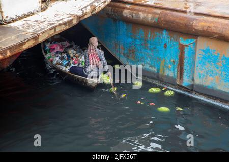 Un homme collecte les déchets plastiques du fleuve Buriganga, Dhaka, Bangladesh Banque D'Images