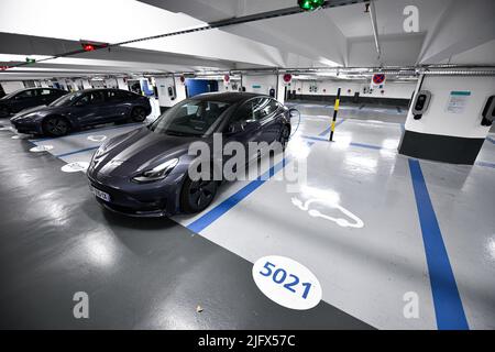 Parking sous l'église de la Madeleine, avec des voitures Tesla branchées pour être rechargées à Paris, France, sur 24 avril 2022. Un demi-millier de stations de charge Banque D'Images