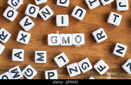 Petits cubes de perles blanches et noires sur bois, lettres en caractères moyens OGM - génétiquement modifié concept alimentaire Banque D'Images