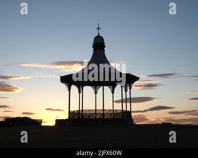 Le Wallace Bandstand, construit en 1884 sur Nairn Links, a silhoueté sur un ciel pâle de coucher de soleil d'été avec des nuages. Banque D'Images