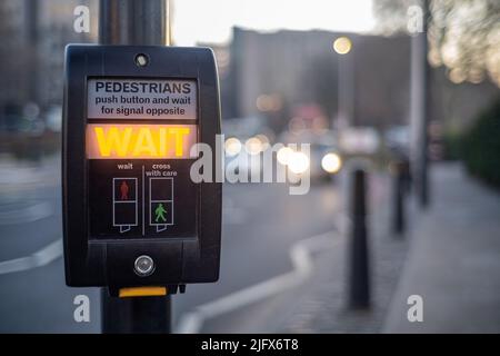 Poteau de signalisation de passage pour piétons avec panneau d'attente allumé Banque D'Images