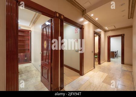 Distributeur d'un bureau avec portes en bois rougeâtre et sol en marbre Banque D'Images