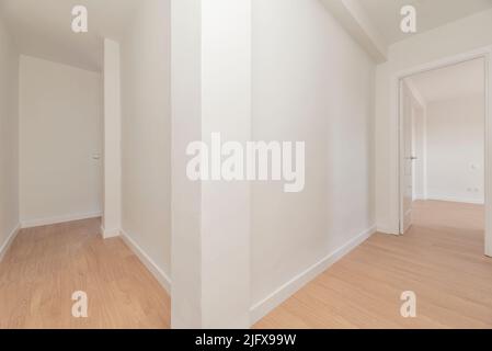 Couloirs de distribution dans une maison vide avec parquet et murs peints en blanc Uni Banque D'Images