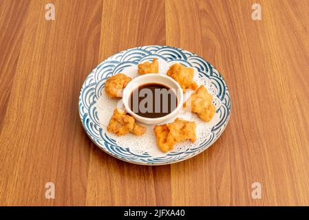 Assiette de petites bouchées de poulet tori katsu avec sauce trempée sur une assiette blanche et bleue Banque D'Images