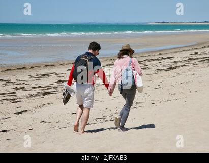 Un jeune couple se promenant tranquillement le long de la plage, Pirou Plage, Normandie, France, Europe Banque D'Images