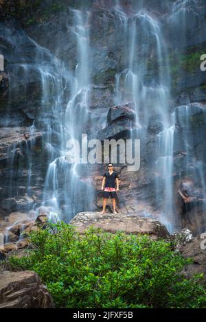 Belle vue sur l'homme en appréciant la grande cascade naturelle sauvage Banque D'Images