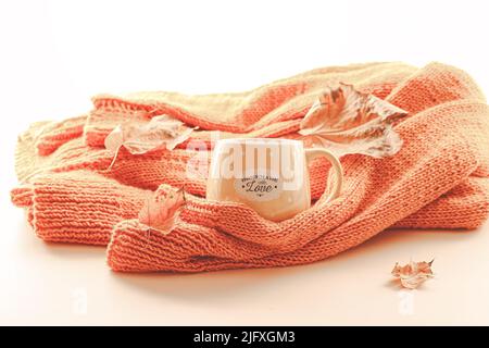 Composition d'automne. Pull en tricot orange avec une tasse de thé et des feuilles d'automne Banque D'Images