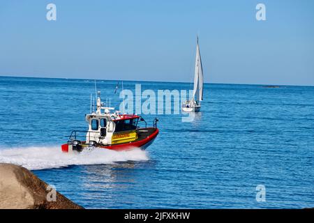 Un bateau de sauvetage de la mer suédoise se dirigeant vers la mer en passant par la côte rocheuse de l'archipel de Fjällbacka en juin 2022 Banque D'Images