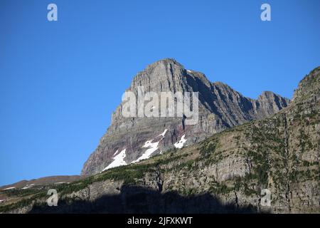 Parc national des Glaciers Montana USA - Logan Pass, en direction de Sun Rd, ciel bleu brillant au-dessus des majestueuses roches sédimentaires à bandes de couleur de Clements Mountain Banque D'Images