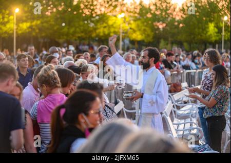 Un prêtre bénit les articles religieux des fidèles après la Messe du soir à Medjugorje le 4 septembre 2021. Banque D'Images