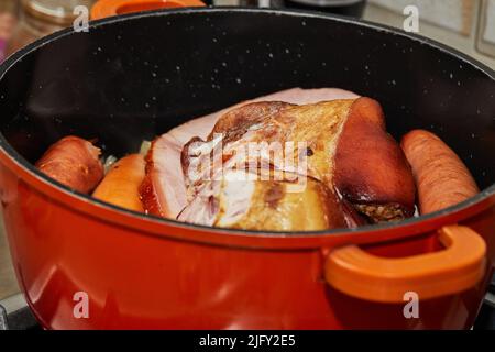 Morceaux de porc fumé et saucisses dans une casserole pour faire de la choucroute alsacienne Banque D'Images