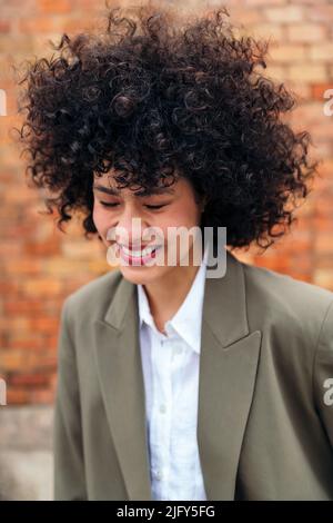 portrait d'une jeune femme avec des cheveux bouclés riant Banque D'Images