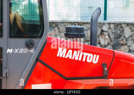 30 mai 2022, Antalya, Turquie : logo de la société française Manitou près du tuyau d'échappement d'un puissant tracteur. Le concept de pollution environnementale par le carbone di Banque D'Images