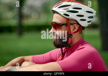 Cycliste prenant le repos dans les herbes vertes. L'été, bonne humeur. Banque D'Images