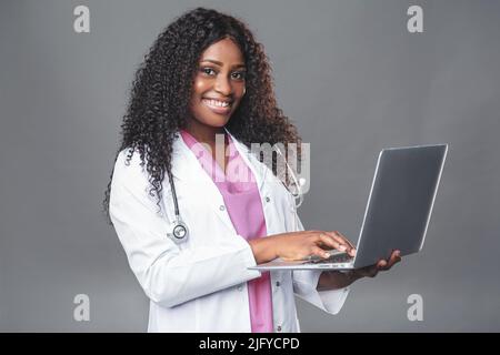 Une femme africaine médecin tenant un appel téléphonique au patient pour passer un appel vidéo en ligne par télémédecine. Consultation à distance d'un thérapeute afro-américain en télémédecine v Banque D'Images