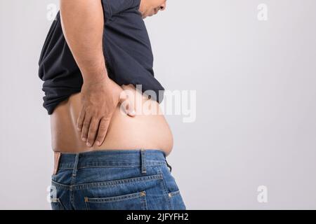 Douleur du corps, douleur de la hanche ou effet du foie problème : gras homme utilisant sa main et appuyant sur la position de la hanche. Studio tourné sur fond gris. Banque D'Images