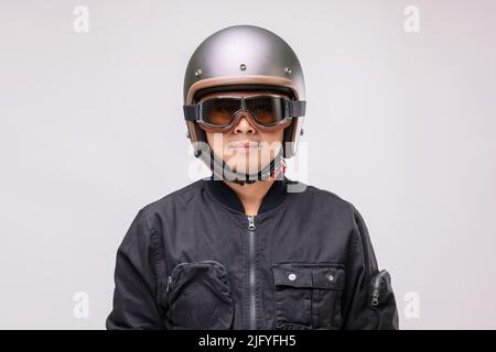 Motard ou pilote portant un casque vintage. Concept de sécurité. Studio tourné sur fond gris Banque D'Images