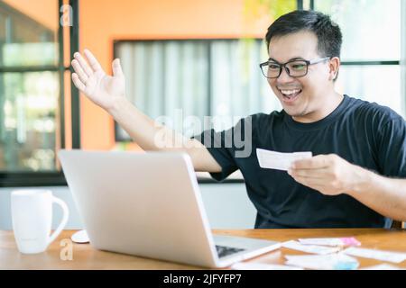 Gagnant du concept de loterie du gouvernement : peuple thaïlandais vérifiant le résultat de la loterie du gouvernement thaïlandais sur ordinateur portable et très heureux action après avoir gagné. Sélection Banque D'Images