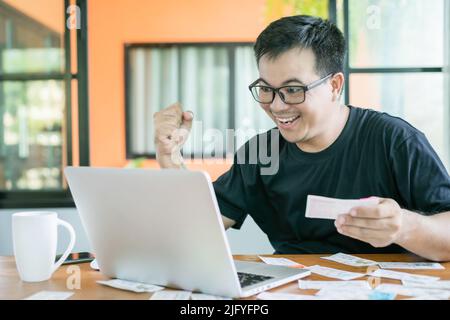 Gagnant du concept de loterie du gouvernement : peuple thaïlandais vérifiant le résultat de la loterie du gouvernement thaïlandais sur ordinateur portable et très heureux action après avoir gagné. Sélection Banque D'Images