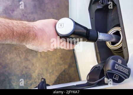 Main d'un homme ravitaillant avec le tuyau dans le réservoir d'une voiture. Banque D'Images