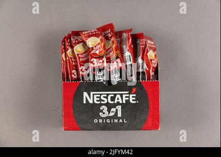 Bâtonnets de café instantané Nescafé dans une boîte en carton sur fond gris. Café avec lait et sucre. Nestlé est une société multinationale suisse. Son headquar Banque D'Images