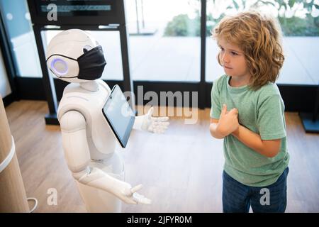 un petit garçon interagit avec l'intelligence artificielle du robot, la technologie future Banque D'Images