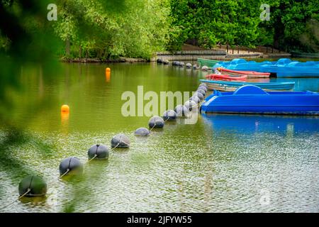 Vue sur un petit étang de lac avec une rangée de bateaux à aubes garés, Crystal Palace Park, Londres, Royaume-Uni Banque D'Images