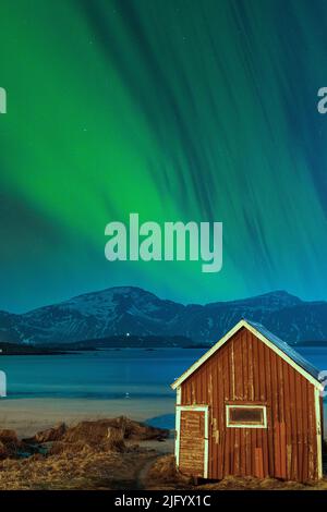 Aurora Borealis (aurores boréales) au-dessus de la cabine rouge sur la plage de Ramberg, comté de Nordland, îles Lofoten, Norvège, Scandinavie, Europe Banque D'Images