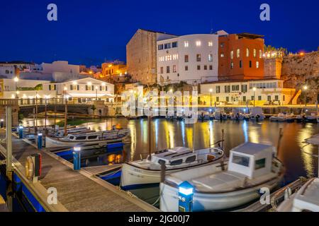 Vue sur les bateaux dans la marina surplombait par des bâtiments blanchis à la chaux au crépuscule, Ciutadella, Menorca, Iles Baléares, Espagne, Méditerranée, Europe Banque D'Images