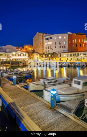 Vue sur les bateaux dans la marina surplombait par des bâtiments blanchis à la chaux au crépuscule, Ciutadella, Menorca, Iles Baléares, Espagne, Méditerranée, Europe Banque D'Images