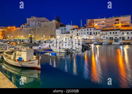 Vue sur les bateaux dans la marina surplombait par des bâtiments blanchis à la chaux au crépuscule, Ciutadella, Menorca, Iles Baléares, Espagne, Méditerranée, Europe Banque D'Images