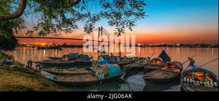 Kolkata, 18, mars 2013; vue panoramique du pont Vidyasagar Setu et des bateaux locaux avec des réflexions dans la rivière Hooghly au crépuscule, Kolkata, Bengale occidental, I Banque D'Images