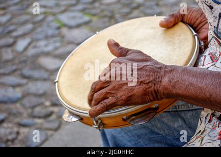 Mains et instrument de percussionniste jouant du tambourin dans les rues du célèbre quartier Pelourinho dans la ville de Salvador à Bahia Banque D'Images