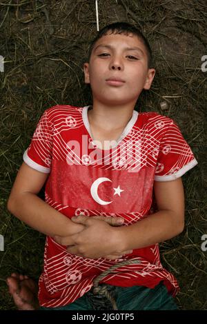 Kırkpınar (Wrestling du pétrole turc). Une jeune couronne vêtue d'un t-shirt rouge avec un drapeau national turc représenté sur lui se trouve sur le terrain en attendant son combat pendant le tournoi Kırkpınar 648th à Edirne, Turquie, le 4 juillet 2009. Banque D'Images