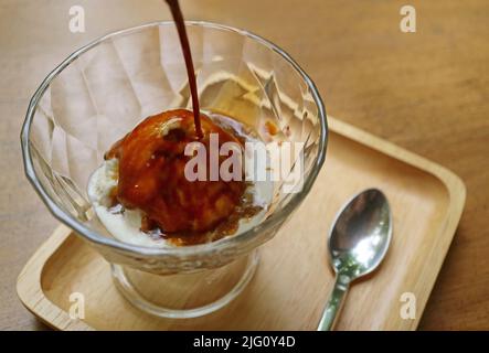 Crème glacée crémeuse à la vanille versée avec une dose d'espresso pour une tasse d'Affogato Banque D'Images
