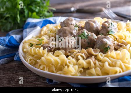 Pâtes avec boulettes de viande suédoises et sauce à la crème sur une assiette. 'Köttbullar' traditionnel Banque D'Images