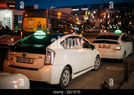 Tbilissi, Géorgie - 28 mars 2022: Vue sur le prius de Toyota blanc utilisé comme taxi. Conception de voyages en ville. Voitures de taxi Toyota Prius plus blanches en attente Banque D'Images