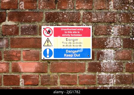 Danger, tenir à l'extérieur et panneau d'avertissement de danger sur le mur en brique rouge Banque D'Images