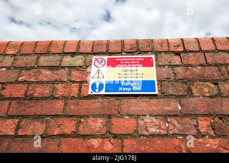 Danger, tenir à l'extérieur et panneau d'avertissement de danger sur le mur en brique rouge Banque D'Images