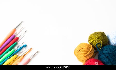 Vue de dessus des crochets en crochet et des boules de laine, des crochets en crochet colorés et des boules de laine isolées sur un fond blanc. Photo à plat. Copier l'espace. Banque D'Images