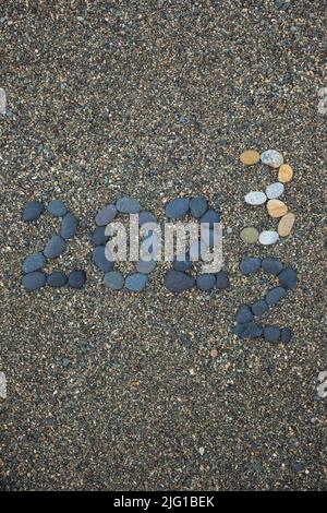 Retournement de 2022 à 2023 fait de pierres sur la plage. Préparation changement de nouvelle année Banque D'Images