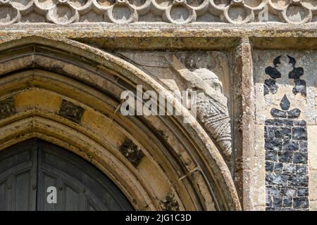 Des anges de pierre sculptés dans les coins de cadre de porte de l'église All Saints, Laxfield, Suffolk Banque D'Images